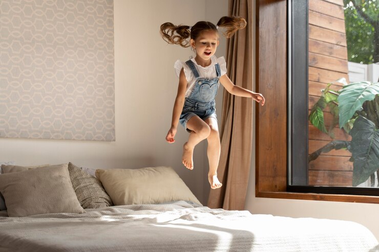 Bambina che salta sul letto